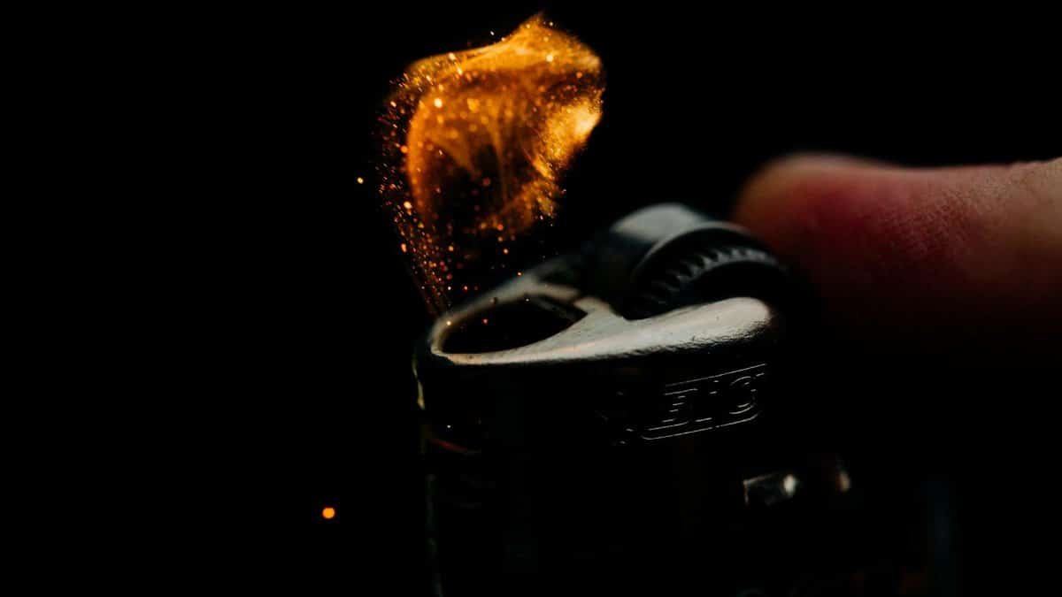 A macro shot capturing the ignition spark of a lighter in a dim setting.