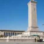 Monument to the People's Heroes in Tiananmen Square, Beijing, China, under a clear blue sky.