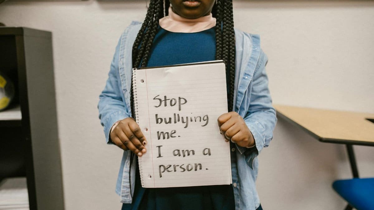 African American girl with empowering anti-bullying message in school setting.