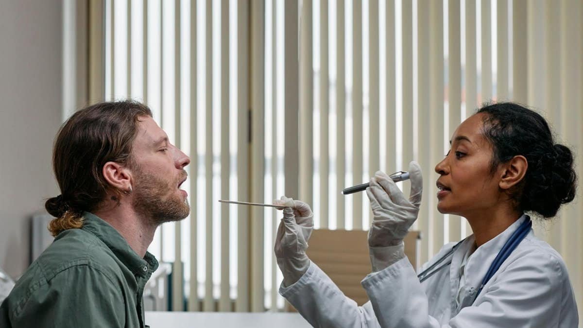A doctor examining a patient's throat in a clinical setting, highlighting professional healthcare.