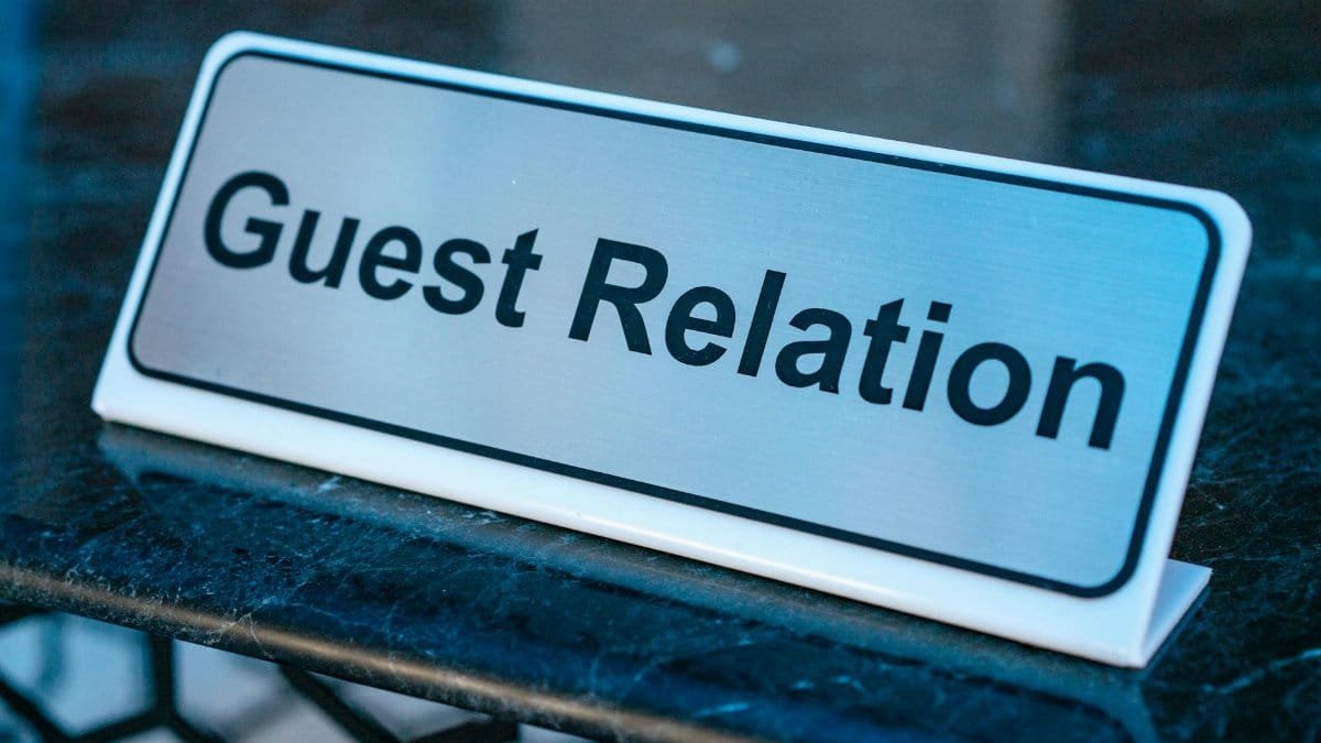 Close-up of a guest relation sign on a granite reception desk, ideal for hospitality services.