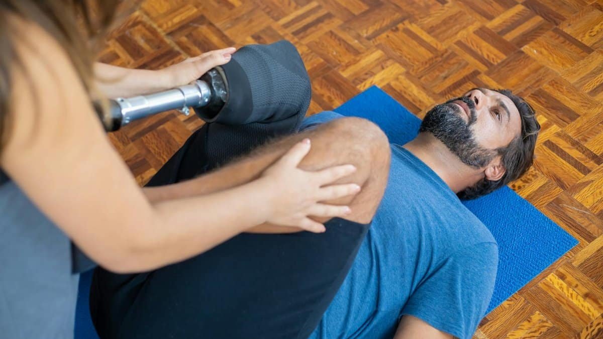 Man with prosthetic leg receiving therapy indoors, aiding recovery and rehabilitation.