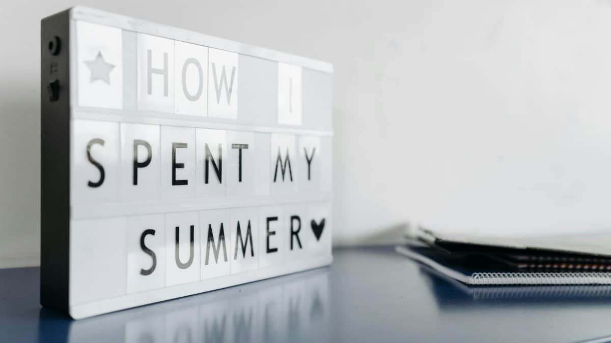 Close-up of a lightbox with 'How I Spent My Summer' text on a desk.