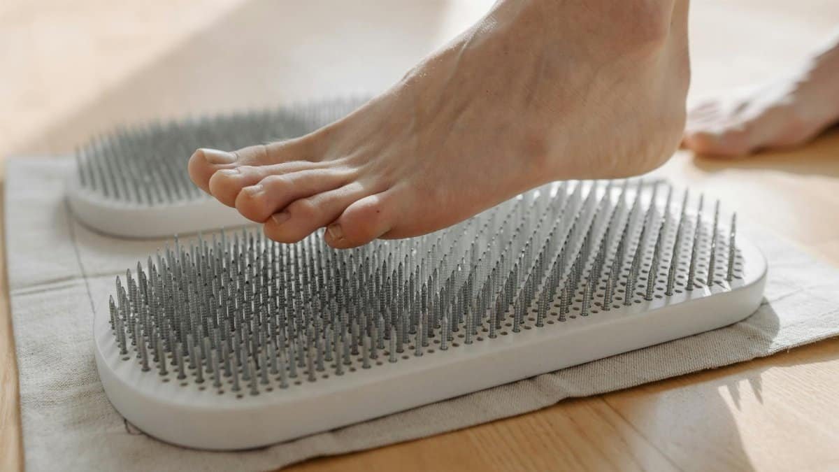 Foot engaging with a sadhu board for acupressure therapy. Relaxation and healing benefits.