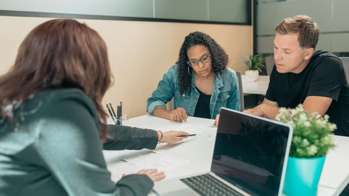 Couple meeting with advisor for adoption process in a modern office setting.