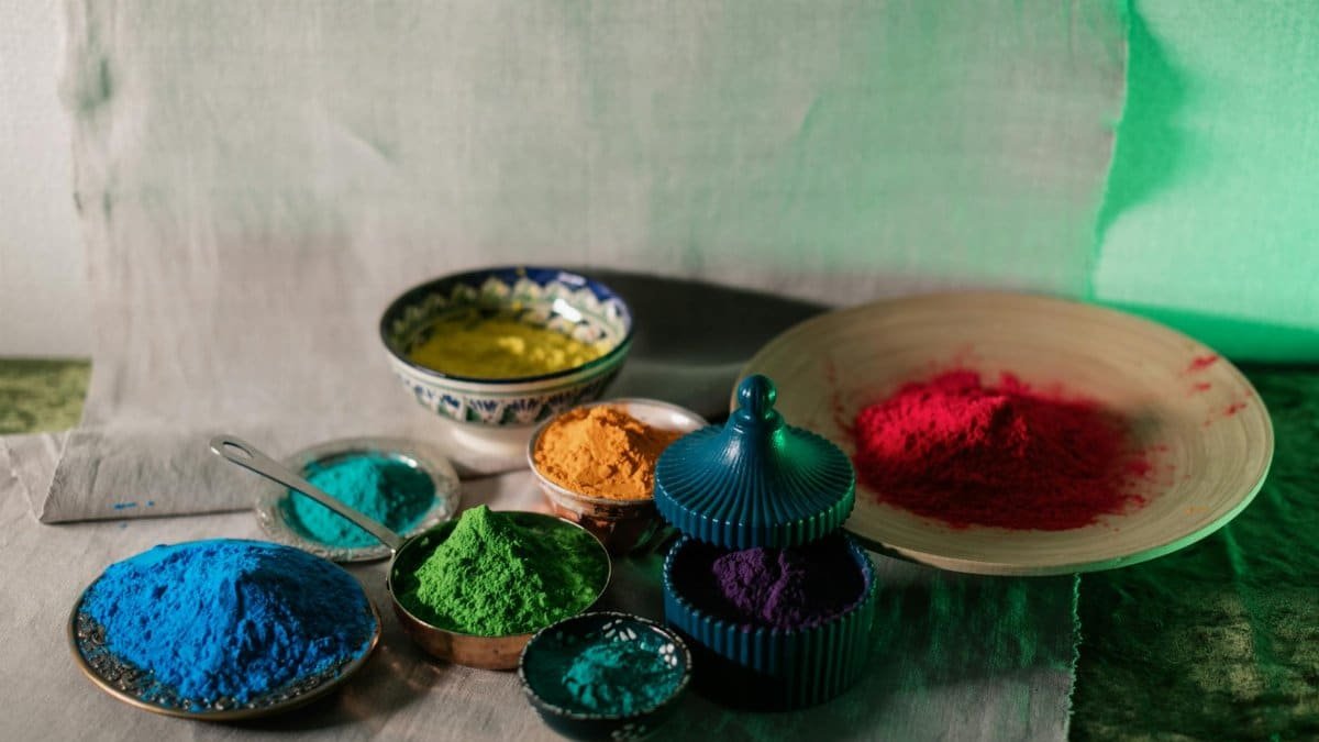 Vibrant Holi powders in various colors displayed in decorative bowls for festive celebrations.