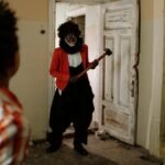 A frightening clown with an axe surprises friends exploring an abandoned building.