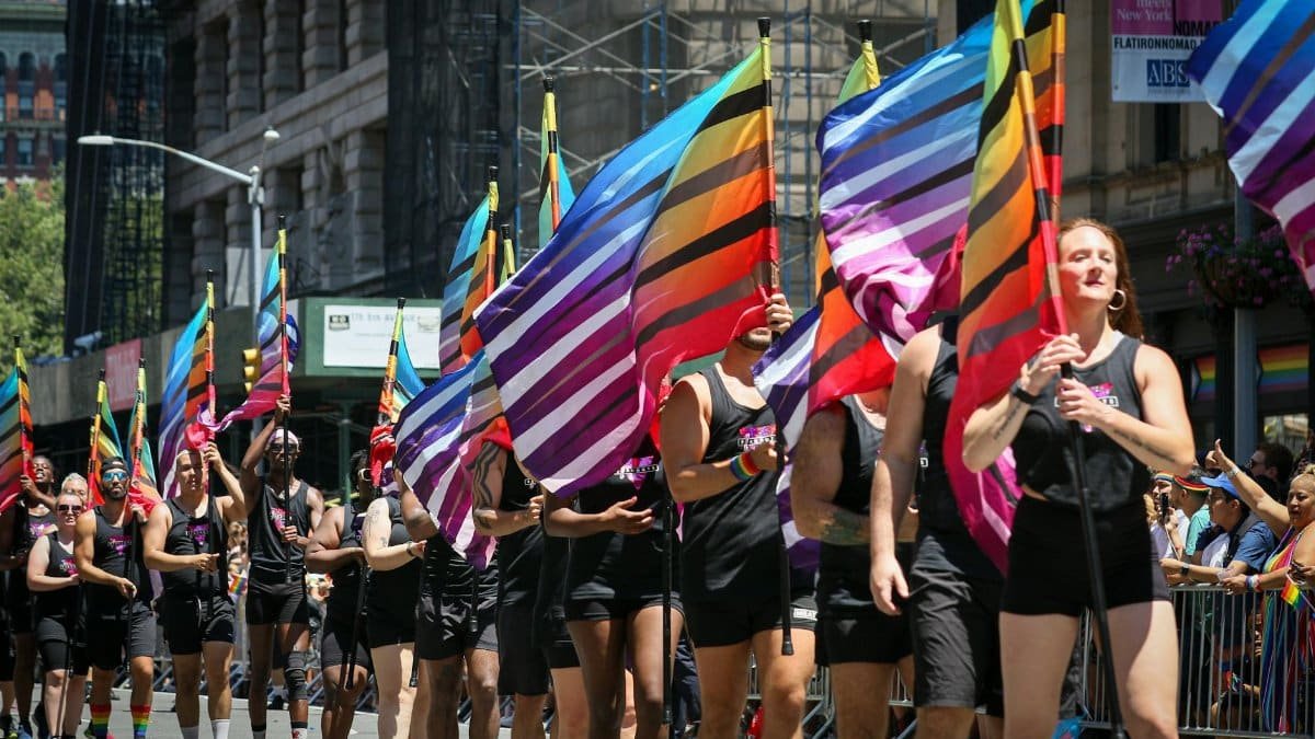 A lively Pride Parade with colorful flags in New York, showcasing diverse participants celebrating LGBTQ culture.