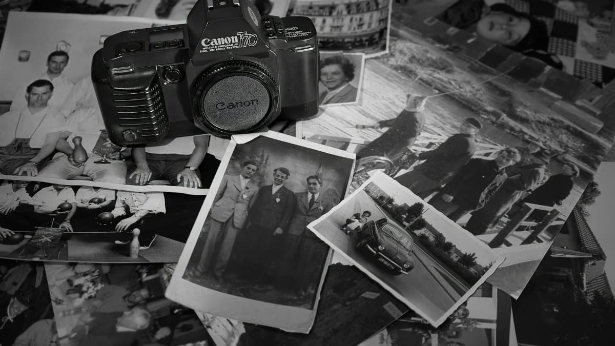 A nostalgic display of a vintage camera surrounded by black and white photographs showcasing memories.