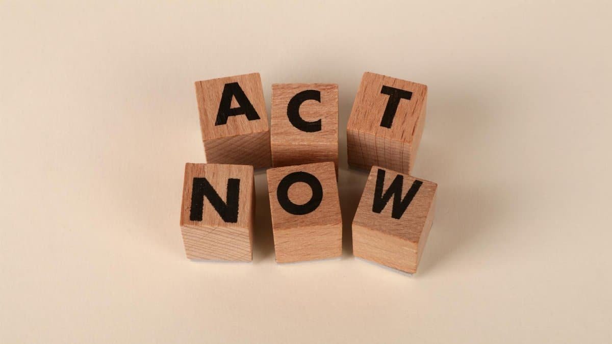 Wooden blocks with letters spelling 'ACT NOW', promoting urgency and motivation.