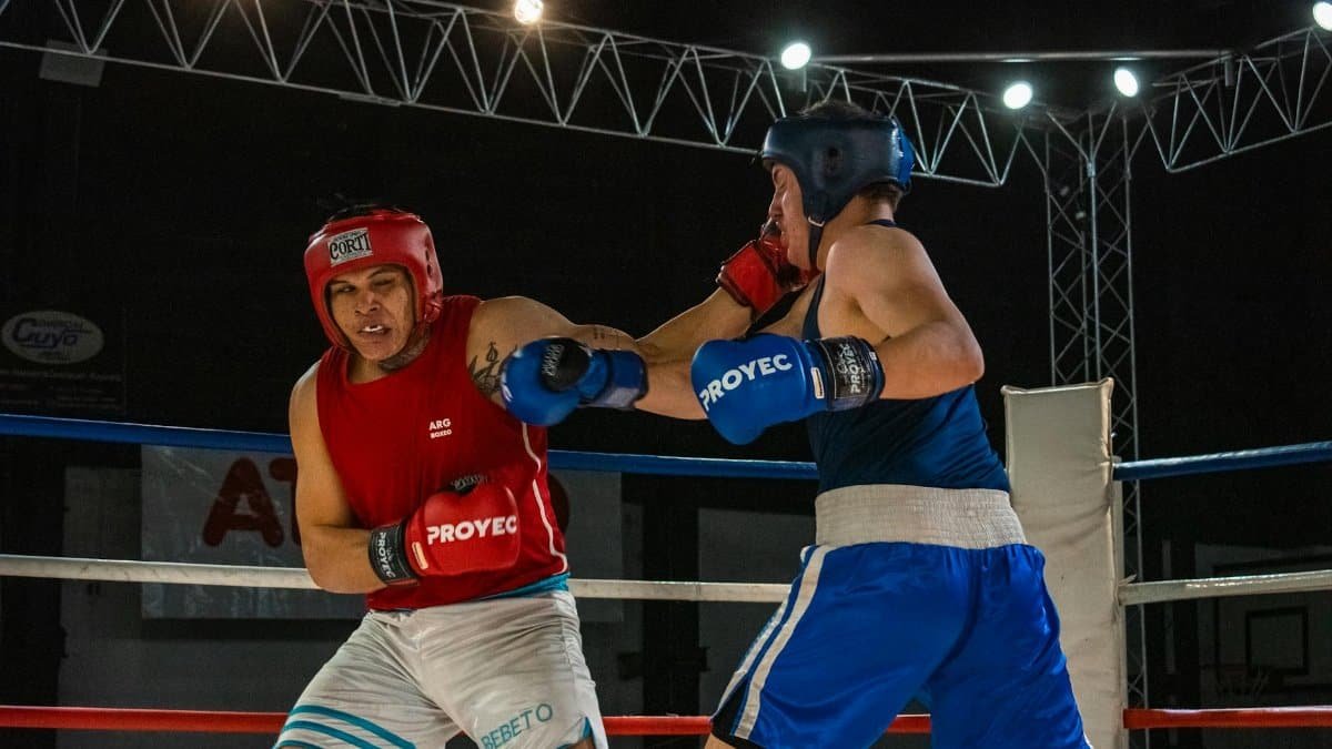 Two boxers engage in a fierce fight in a well-lit boxing ring, showcasing skill and sportsmanship.