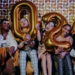 A group of diverse friends celebrating New Year's Eve with balloons and champagne, embodying joy and togetherness.