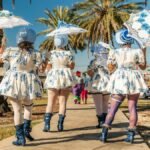 Festive women in costume participate in a vibrant New Orleans Mardi Gras parade.
