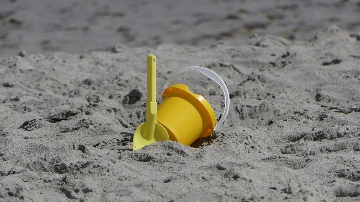 A yellow sand bucket and spade on Ballygally Beach in Northern Ireland.
