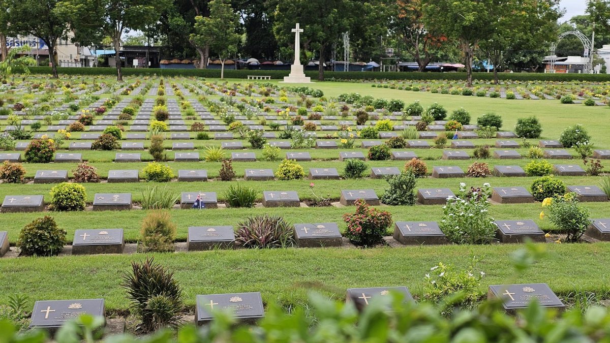 A tranquil view of war graves in Kanchanaburi's beautifully landscaped cemetery.