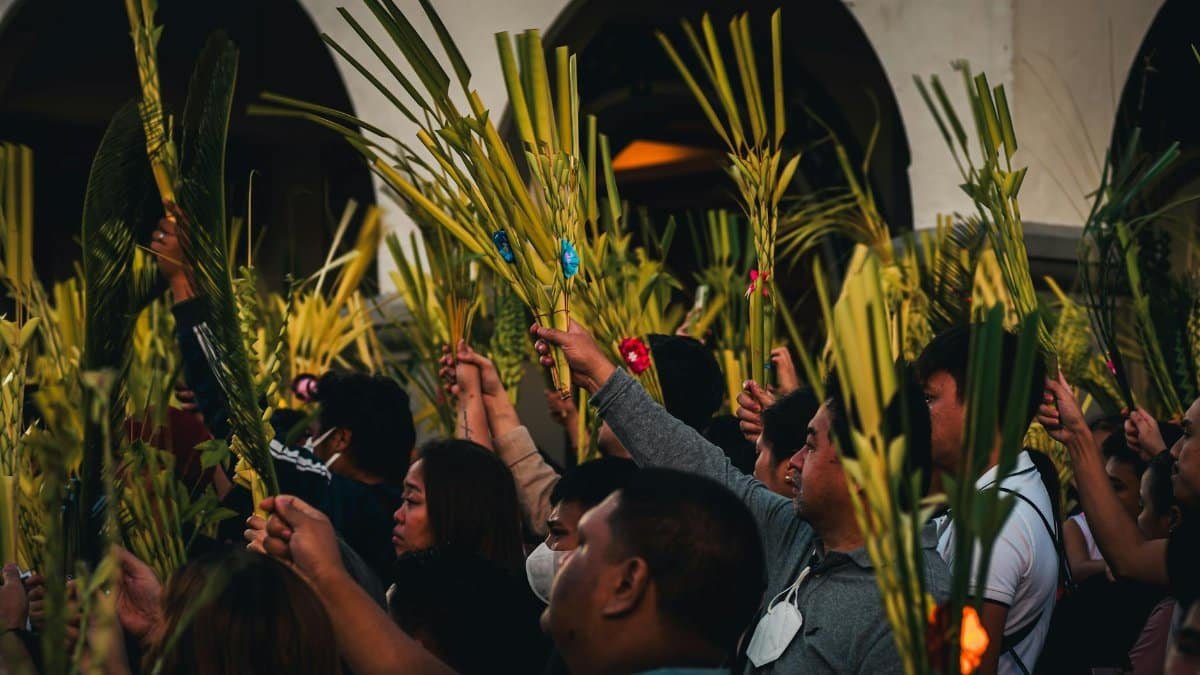 Vibrant Palm Sunday gathering in Baguio City with people holding palm fronds in a cultural celebration.