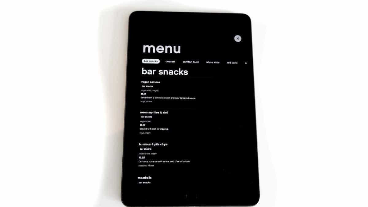 Tablet displaying a digital menu for bar snacks in a modern, minimalistic style.