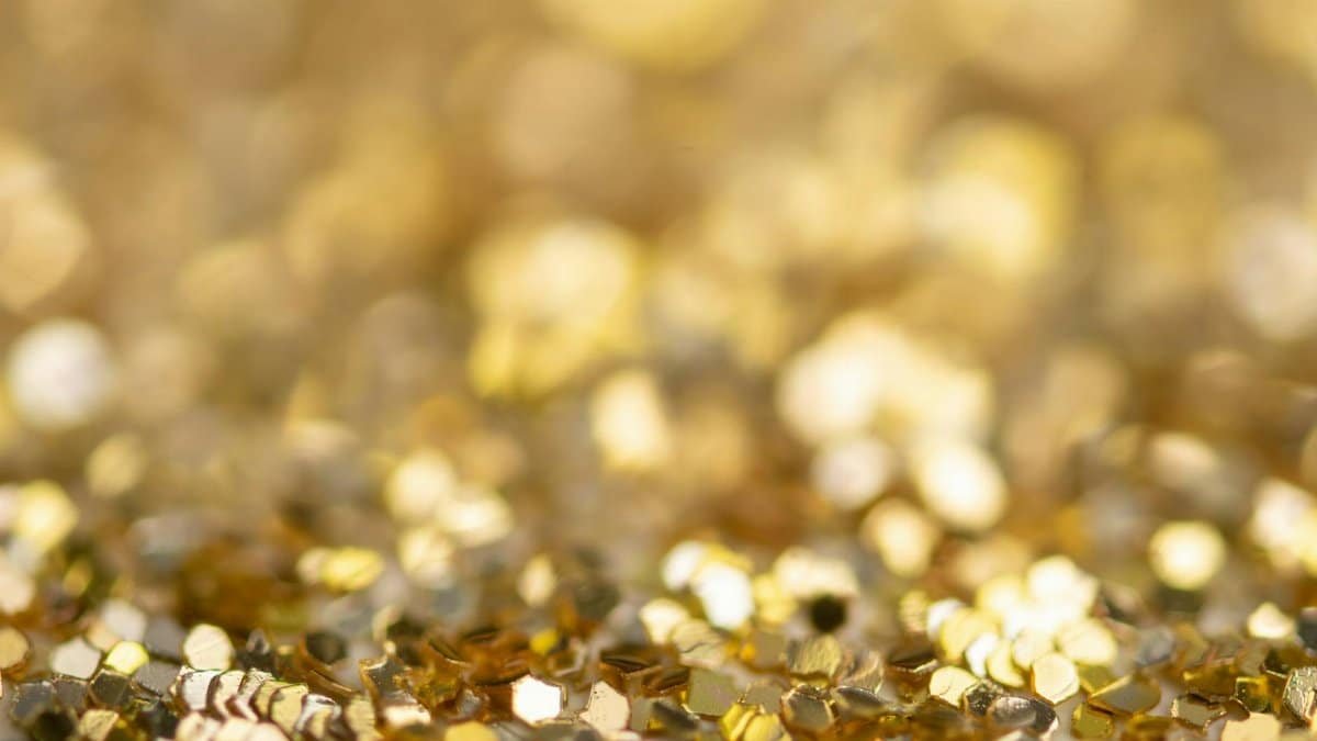 Vibrant and shimmering golden glitter with a soft bokeh effect, perfect for festive and artistic themes.