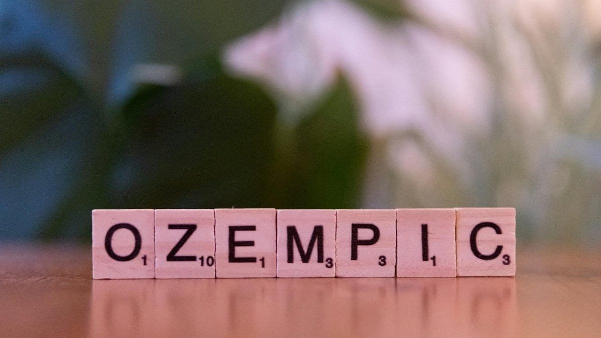 Scrabble tiles spelling 'Ozempic' on a wooden surface, healthcare theme.