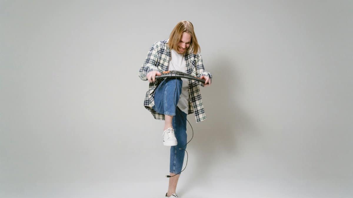 Person expressing frustration by breaking a computer keyboard in a studio setting.
