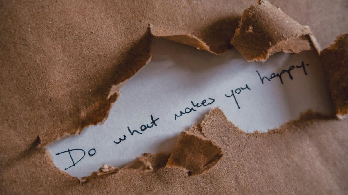 Brown paper revealing message 'Do what makes you happy.'