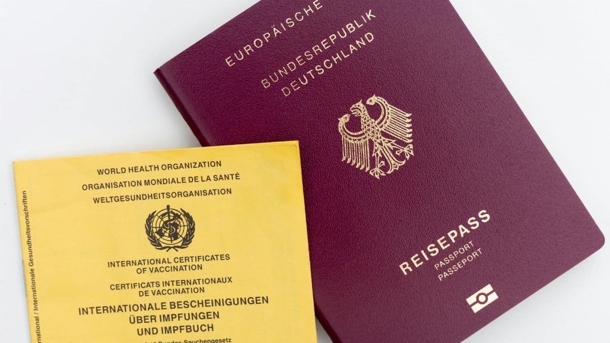Close-up view of a German passport and WHO vaccination card, ideal for travel themes.