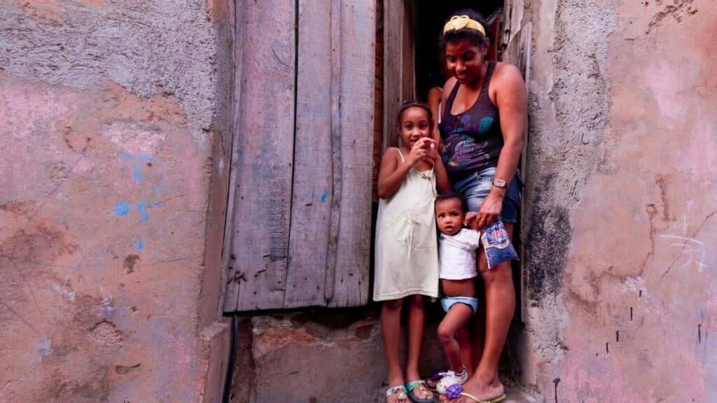 Family standing in a rustic doorway with colorful walls, capturing a candid moment.