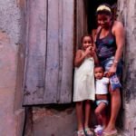 Family standing in a rustic doorway with colorful walls, capturing a candid moment.