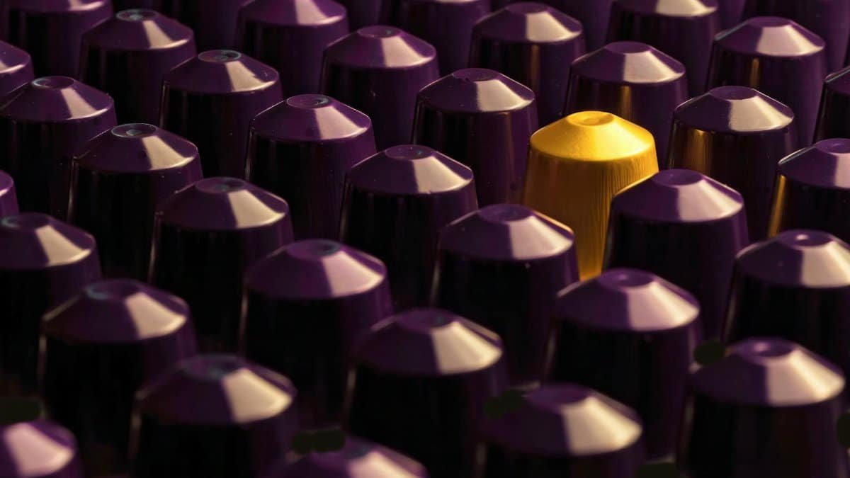 An artistic display of purple coffee pods with a standout gold pod.