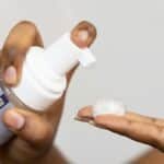 Close-up of hands dispensing soothing foaming face wash, ideal for sensitive skin care.