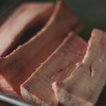 High-quality close-up image of raw beef bone marrow slices on a tray, perfect for cooking concepts.