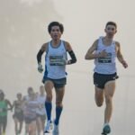 Competitive marathon runners leading the pack on a foggy morning, showcasing endurance and determination.