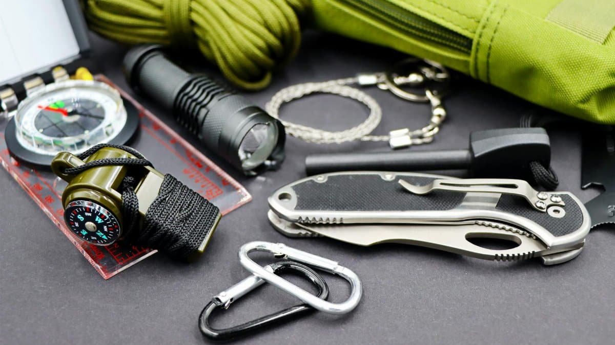 A detailed flat lay of essential survival tools for outdoor adventure and tactical use.