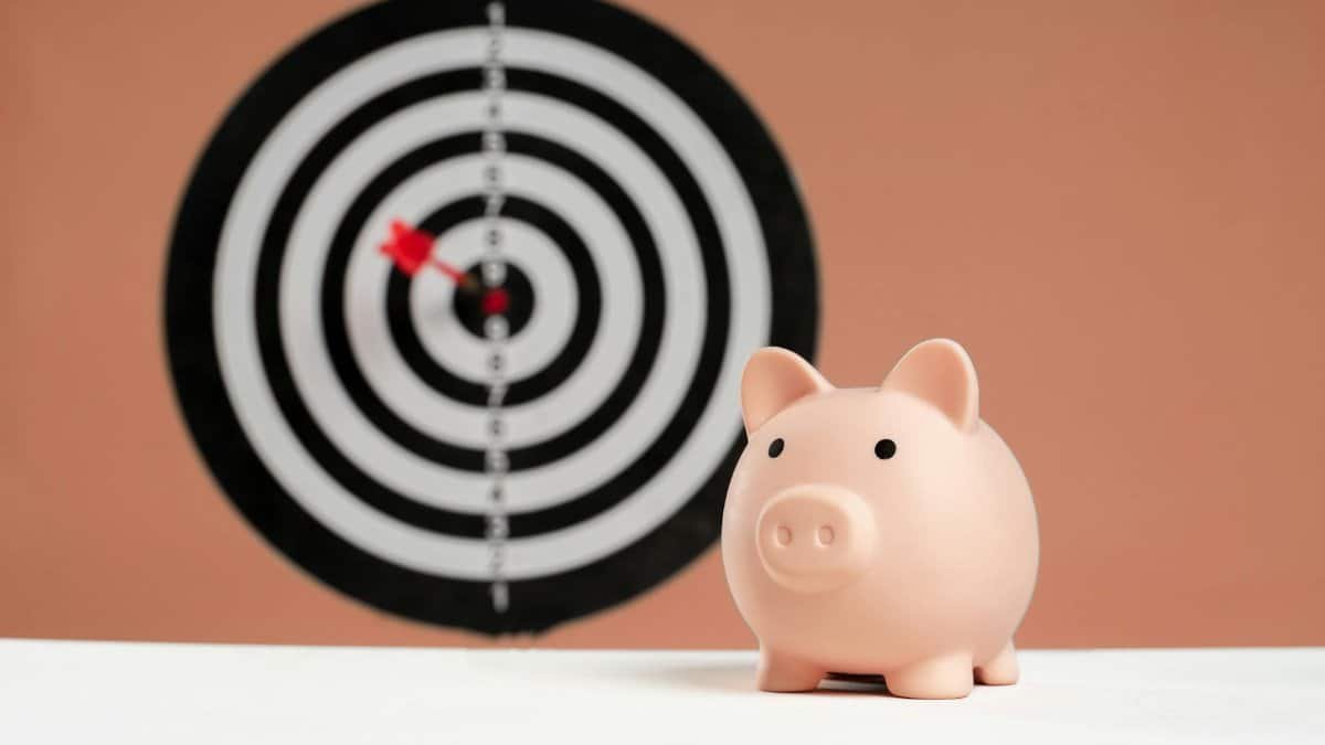 A piggy bank in front of a dartboard symbolizing financial goals and smart savings.