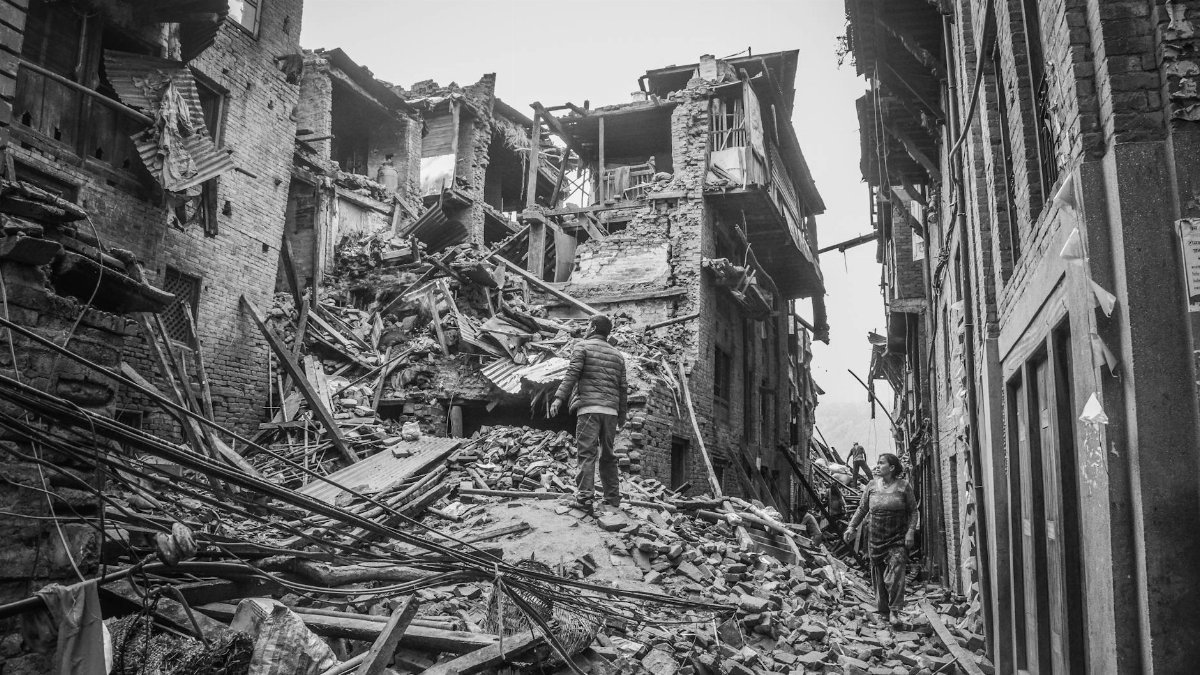 Rubble and destruction in Bhaktapur, Nepal, post-earthquake, capturing the aftermath and human resilience.