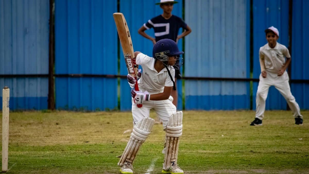 A young cricketer prepares to bat during a match in Gahunje, India.