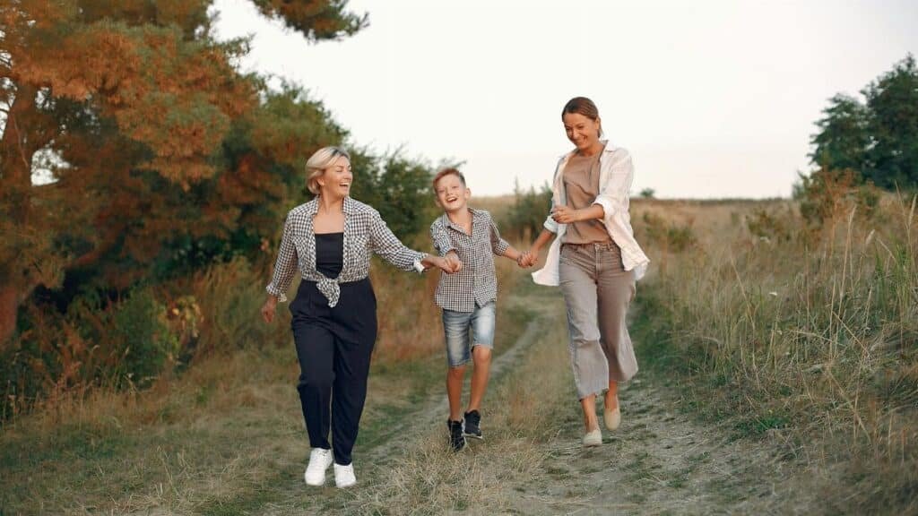 Multi-generational family enjoying a joyful walk outdoors during the summer.