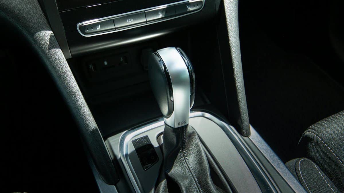 Detail view of a modern car gear shift lever and console interior design.