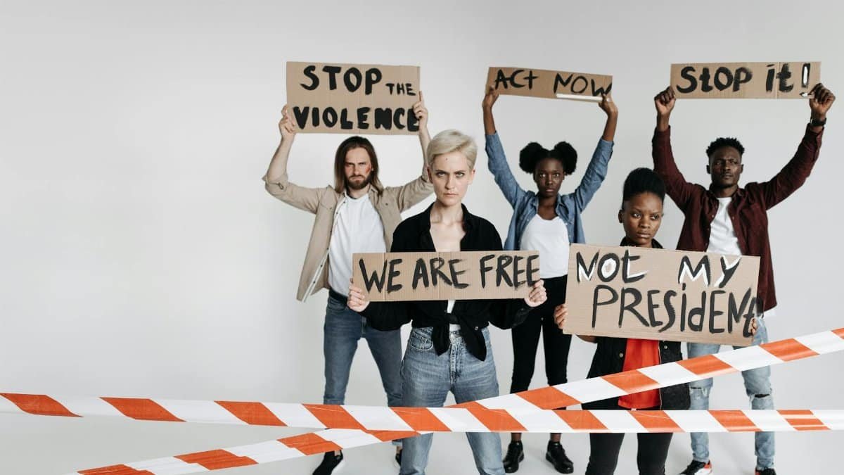 A diverse group protesting with signs, advocating for social change and against violence.
