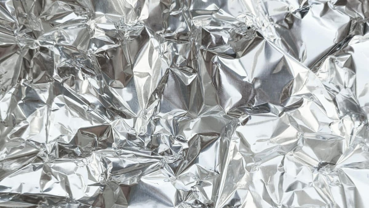Close-up of a crumpled silver aluminum foil texture, perfect for creative backgrounds.