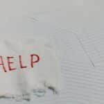 A flag with 'HELP' text on a lined paper background signifying distress or need for assistance.