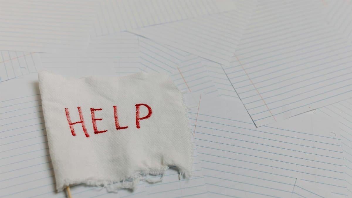 A flag with 'HELP' text on a lined paper background signifying distress or need for assistance.