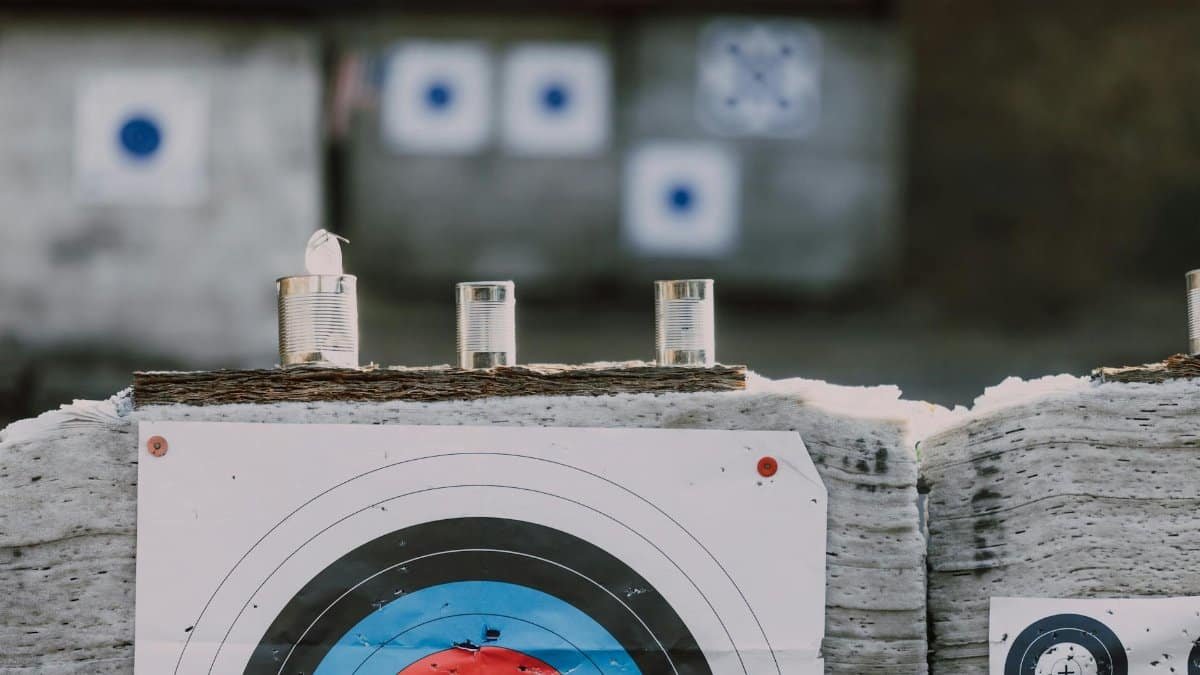 Close-up of archery targets and steel cans used for target practice at an outdoor range.