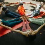 A group of women performing yoga outdoors in a circle, showcasing unity and fitness.