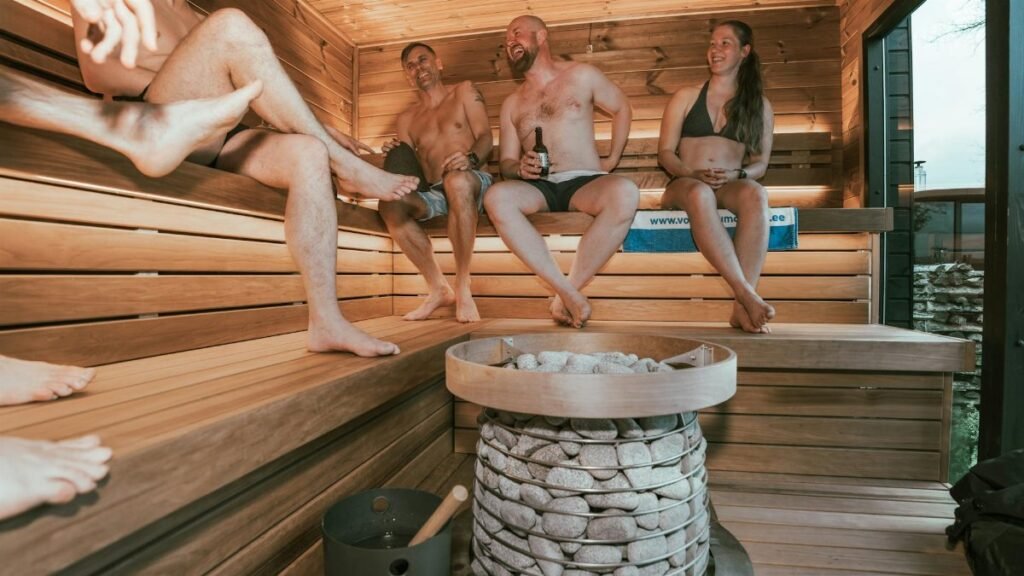 A group of adults enjoying a relaxing session in a modern, nordic-style sauna.