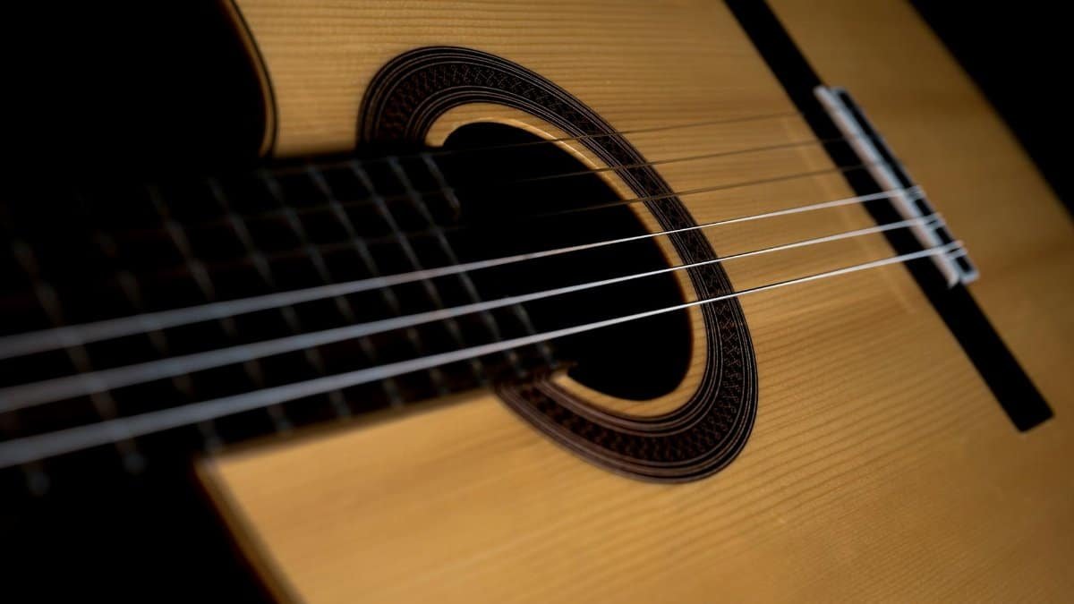 Detailed close-up of a classical acoustic guitar showing the strings and sound hole.
