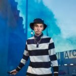 Trendy Gen Z individual with a smoke bomb, showcasing urban street style.