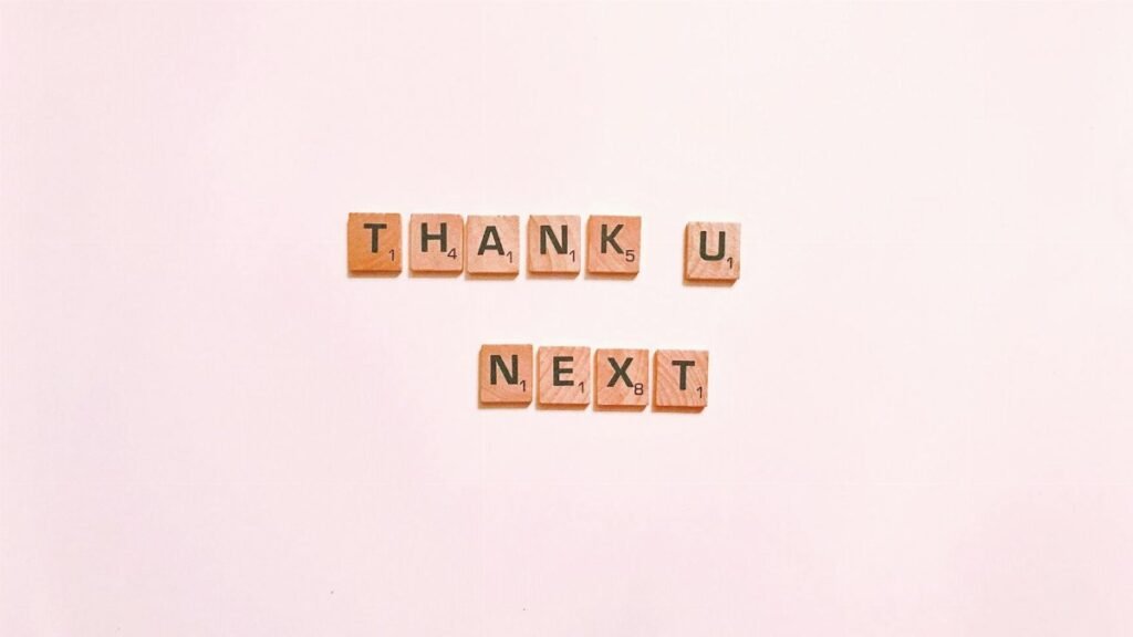 Scrabble tiles display 'Thank U Next' on a clean white background, perfect for creative projects.
