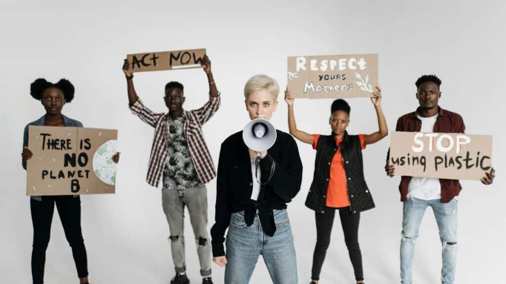 Diverse group of young activists protesting with placards against environmental issues, demanding urgent action.