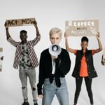 Diverse group of young activists protesting with placards against environmental issues, demanding urgent action.